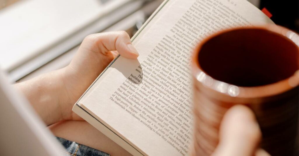 a woman drinking coffee and reading a book